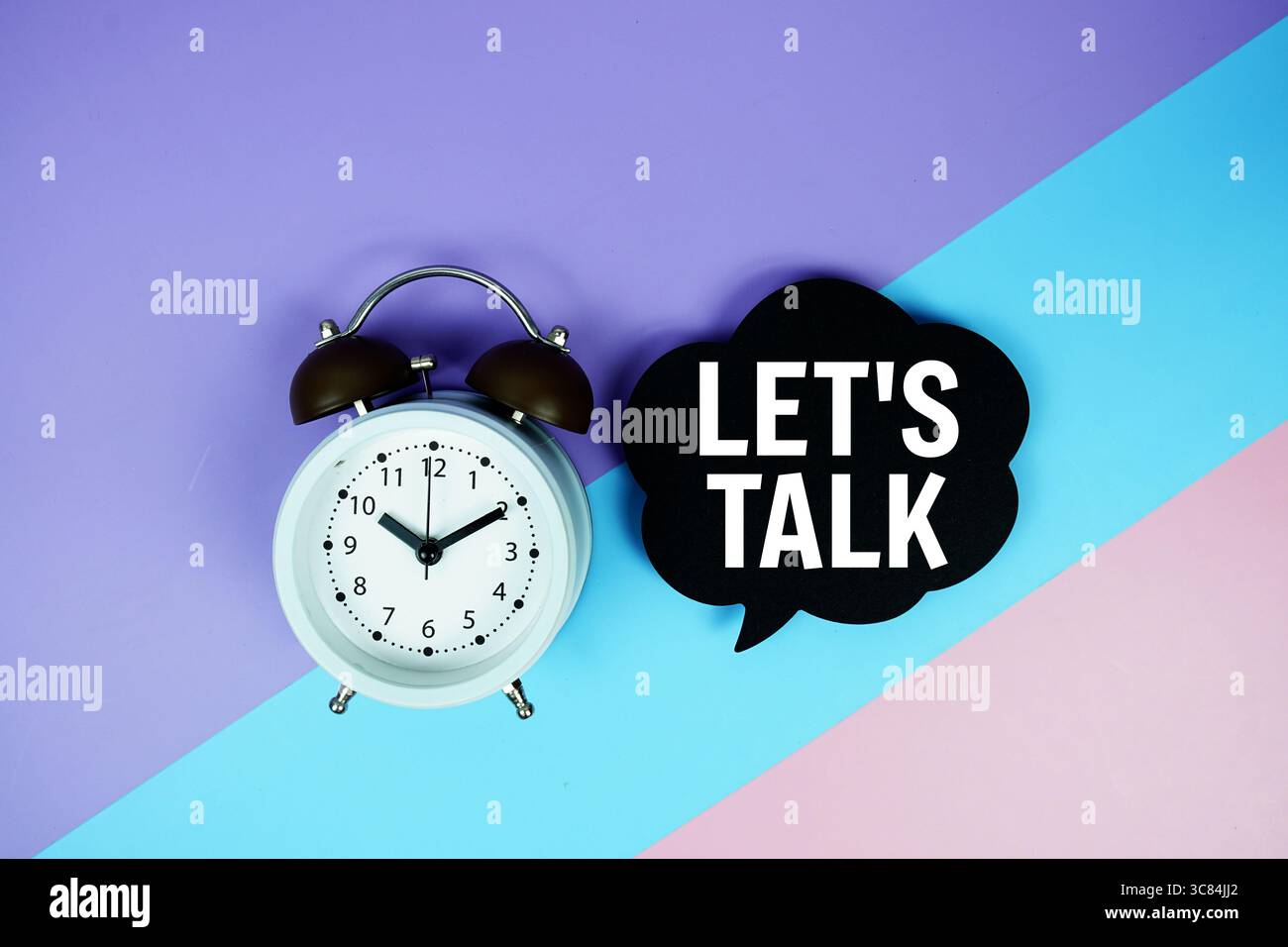 Let's Talk text on speech bubble with alarm clock top view on blue ...