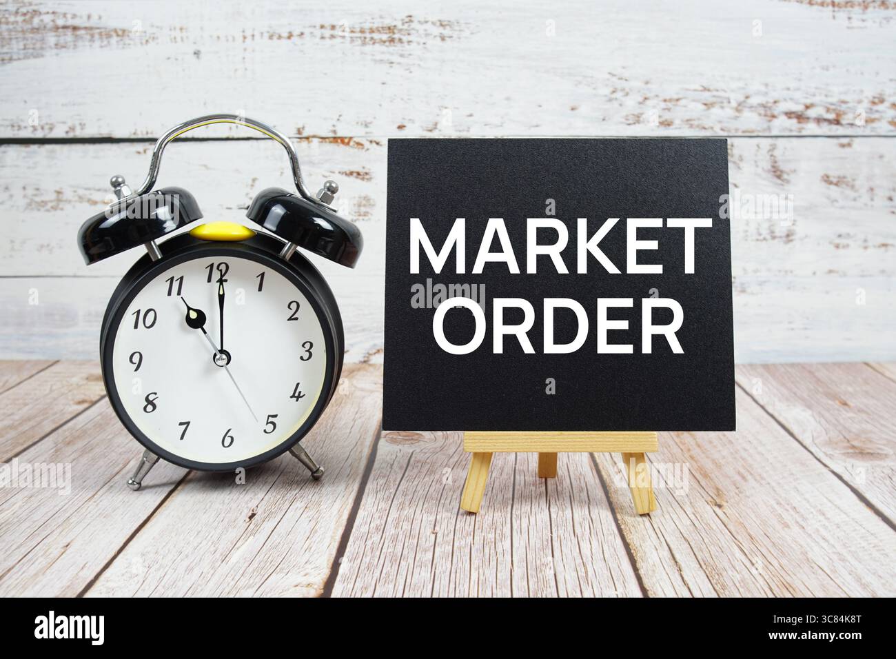 Market Order text with easel and alarm clock on wooden background Stock Photo