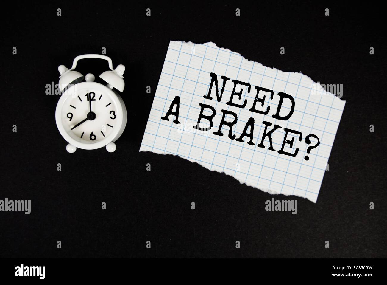 Need A Brake? text written on paper with alarm clock on black background Stock Photo