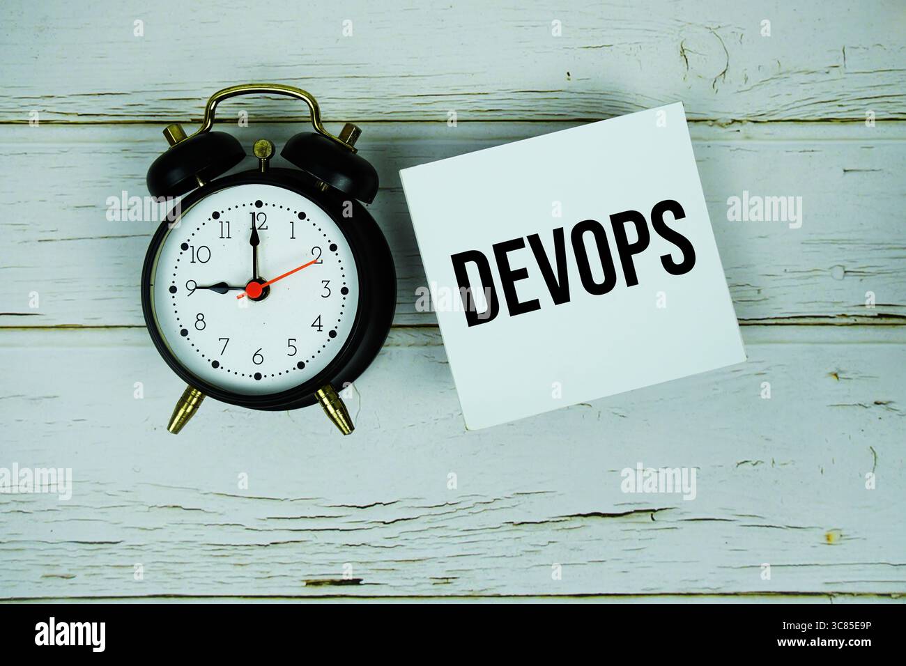 Devops text message on paper with alarm clock on wooden background Stock Photo