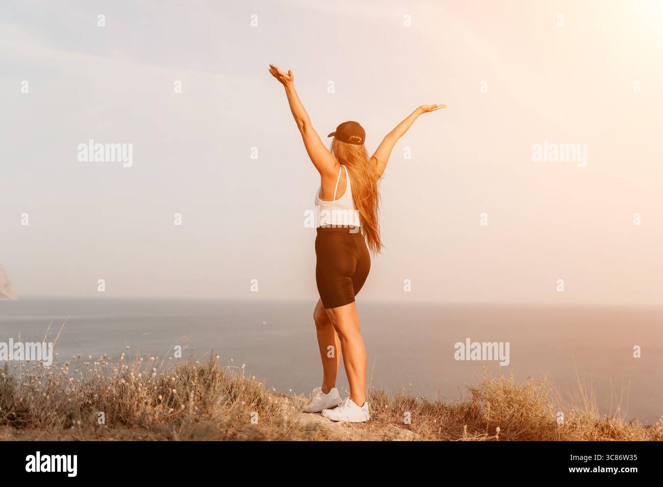 Woman Celebrating on a Clifftop Stock Photo