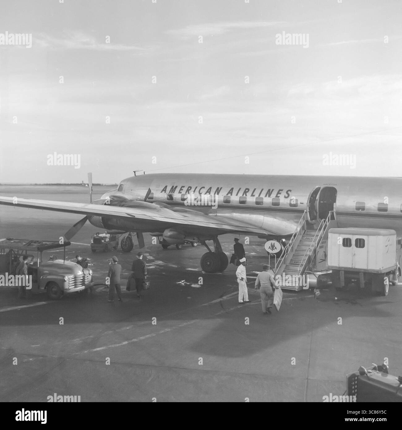 A vintage black and white early 1950s photograph showing an American Airlines Douglas DC-6 airliner being prepared for a flight in the USA. Stock Photo