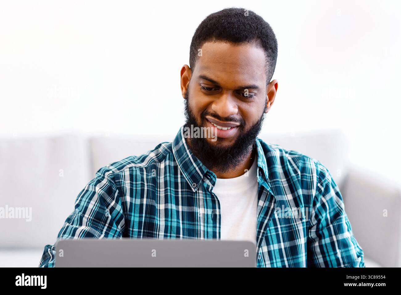 Black Business Guy Working At Laptop Taking Notes In Office Stock Photo