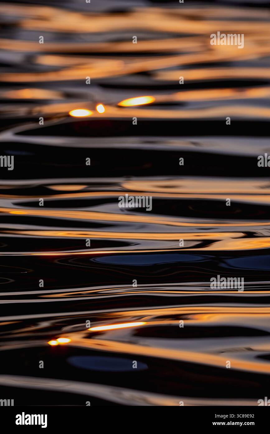 Gilded Ripples Dance Upon Molten Waters Stock Photo