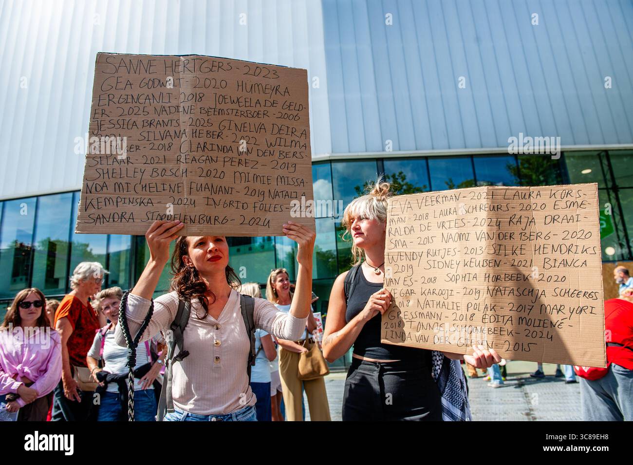 Protesters hold placards with the names of the victims during a demonstration against femicide in Rotterdam. The Dutch feminist organization 'Dolle Mina' held a national protest march against femicide in Rotterdam. This is in response to two murders of women in less than a week. In both cases, the suspect turned out to be a (former) partner of the victim.'Dolle Mina' demands that femicide must be recognized as a 'specific and structural form of gender-based violence.' During the speech of one of the parents of one of the victims, a man ran onto the stage and tried to disrupt the event. Stock Photo