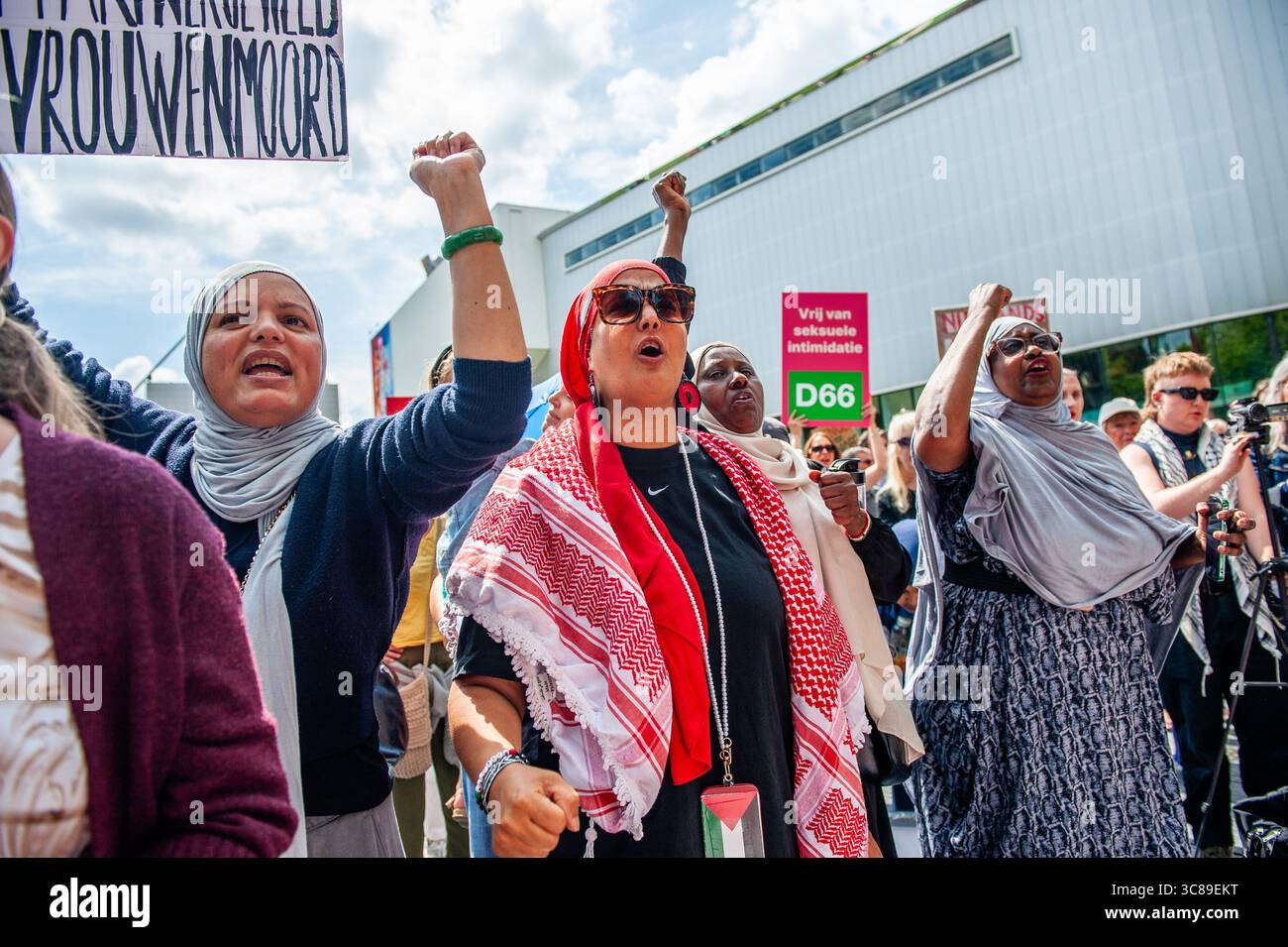 Protesters chant slogans during a demonstration against femicide in Rotterdam. The Dutch feminist organization 'Dolle Mina' held a national protest march against femicide in Rotterdam. This is in response to two murders of women in less than a week. In both cases, the suspect turned out to be a (former) partner of the victim.'Dolle Mina' demands that femicide must be recognized as a 'specific and structural form of gender-based violence.' During the speech of one of the parents of one of the victims, a man ran onto the stage and tried to disrupt the event. Stock Photo