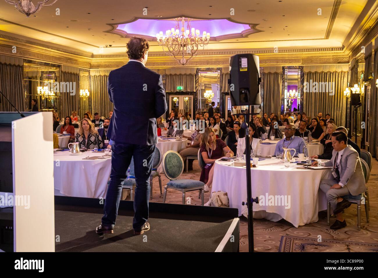 Anonymous speaker addressing a conference seen from behind Stock Photo