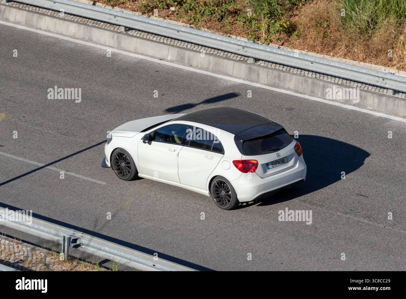 White mercedes benz a class is driving on the highway on a sunny day Stock Photo
