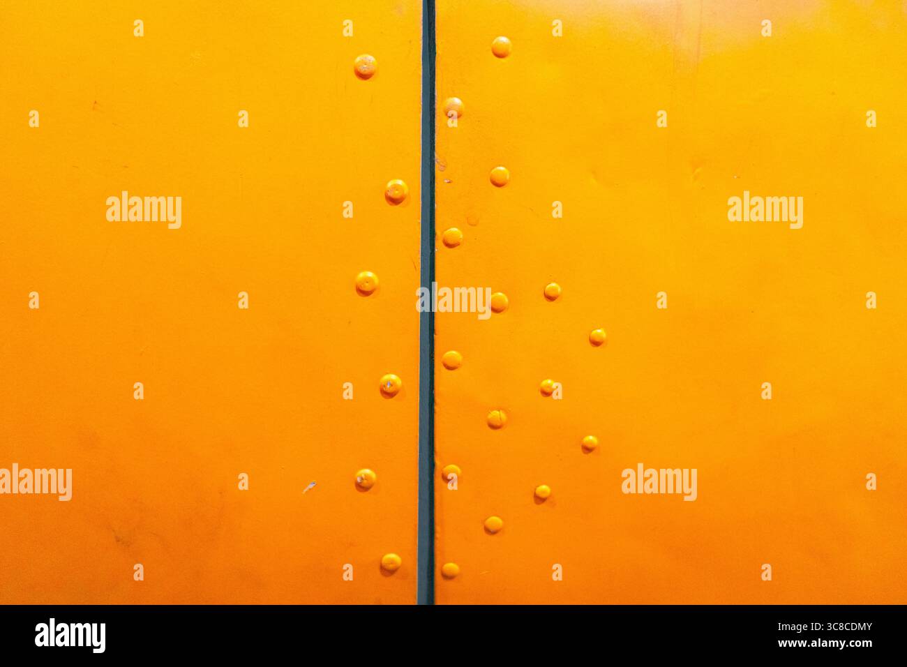 Detail of an old aircraft fuselage painted yellow, showing rivets ...