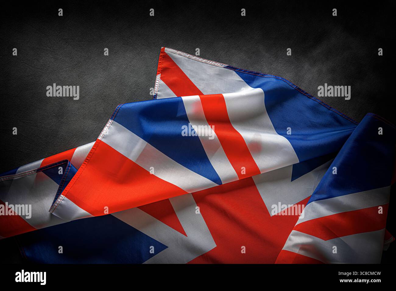 Union Jack flag of the United Kingdom with dramatic lighting and dark background Stock Photo