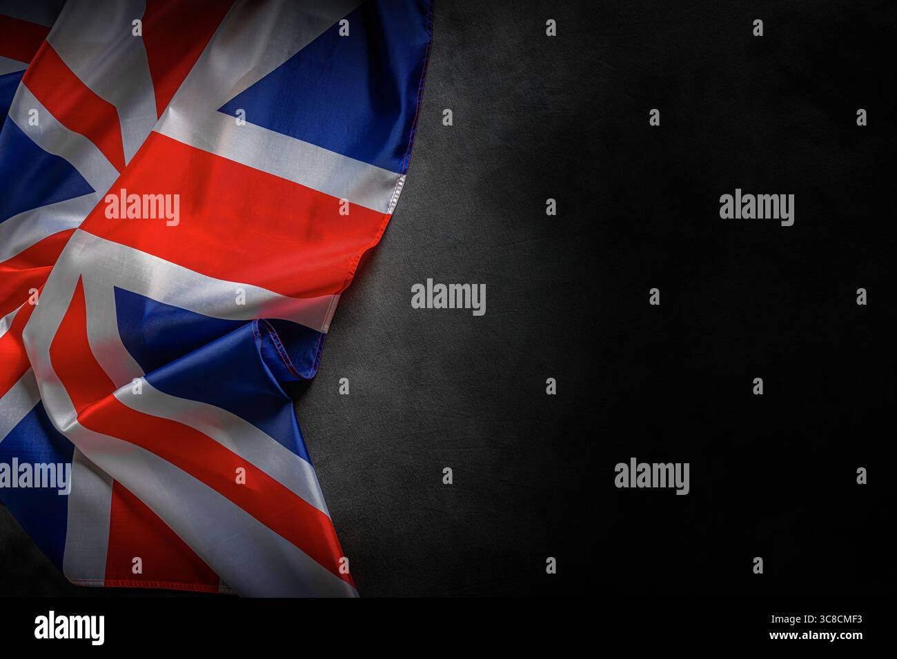 Union Jack flag of the United Kingdom with dramatic lighting and dark background Stock Photo