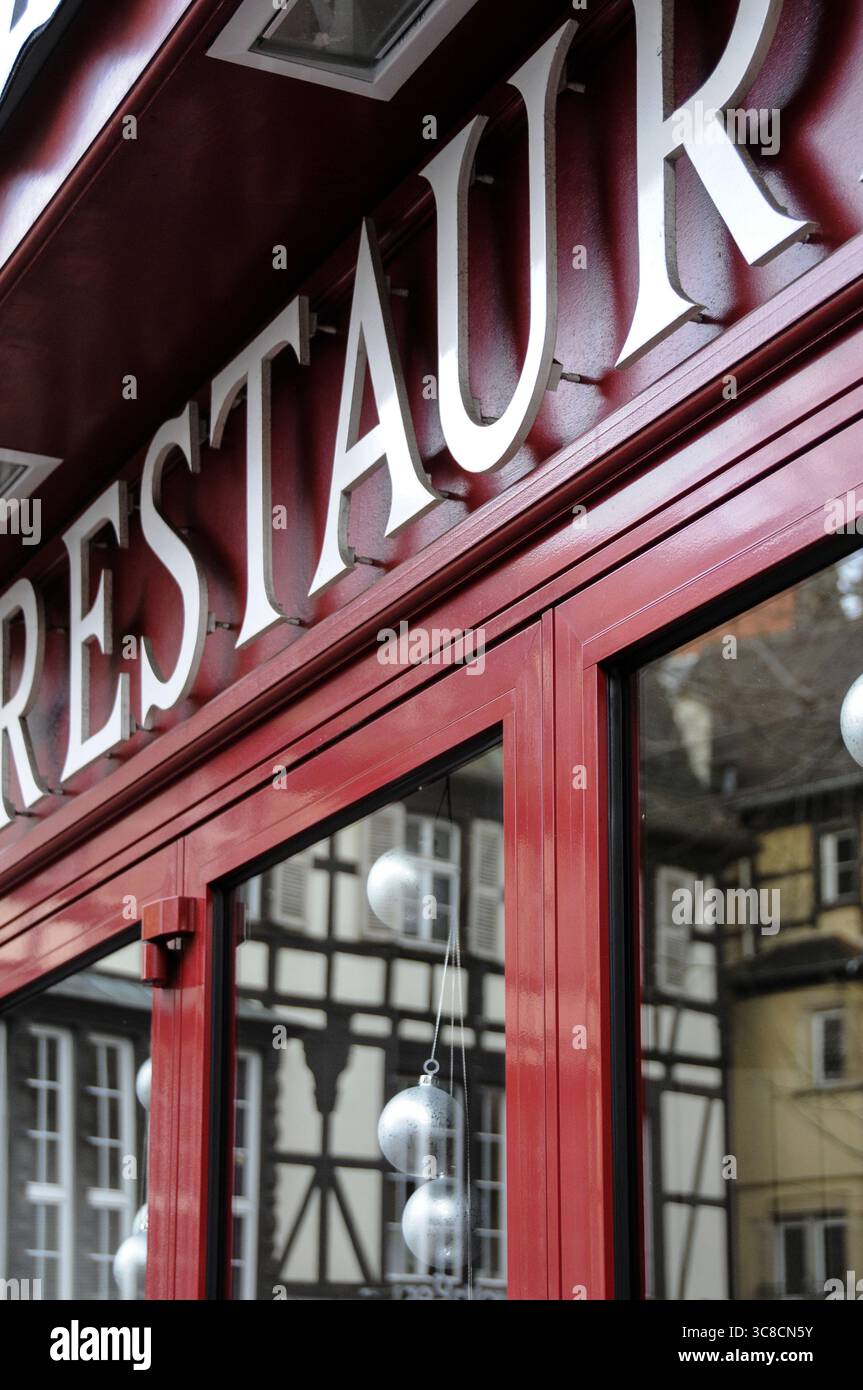 January 2012, Colmar, France. detail of the red exterior of a traditional restaurant in Alsace, with festive decorations and timber-framed reflections Stock Photo