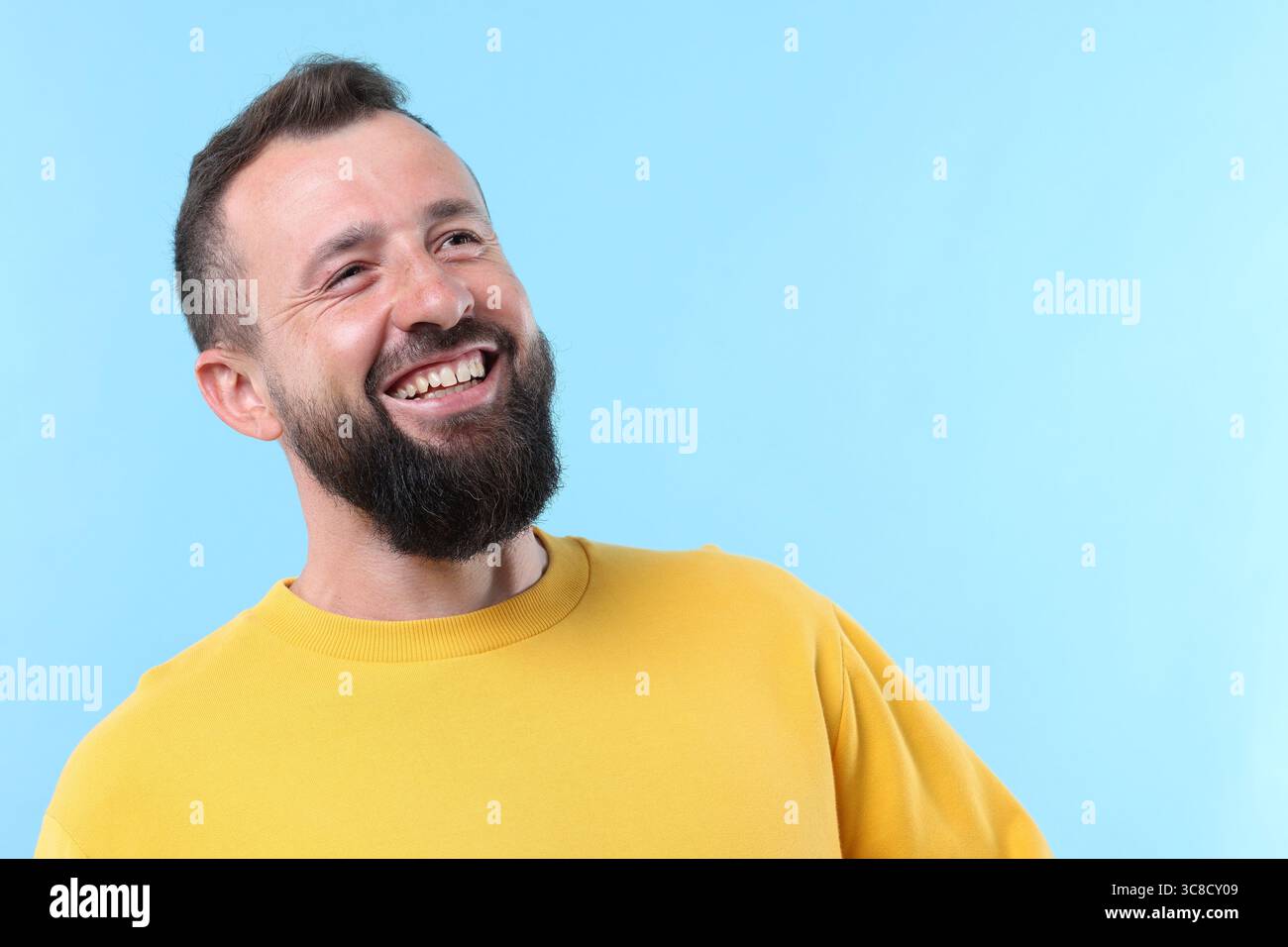 Handsome man laughing on light blue background. Space for text Stock ...