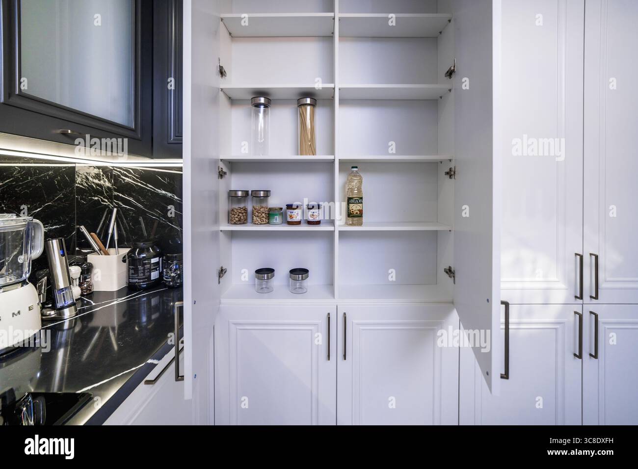 Open cabinets in a new kitchen set. Almost empty shelves. Stock Photo