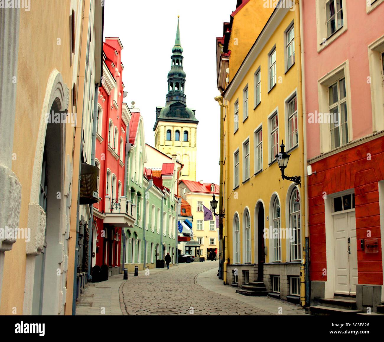 View through the colourful streets of Tallinn, Estonia, to the spire of St. Nicholas Church. Stock Photo