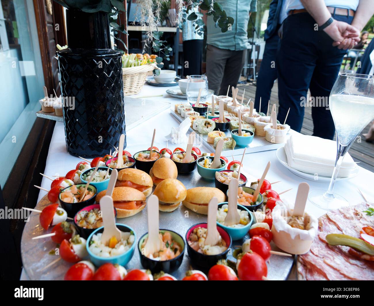 Outdoor appetizer buffet with mini burgers, verrines, tomato-mozzarella ...