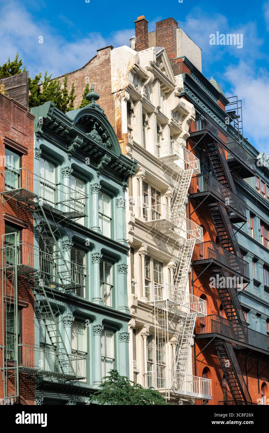 Colorful historic cast iron buildings with ornate facades and fire escapes in SoHo Historic District, Manhattan. Example of 19th century New York City Stock Photo