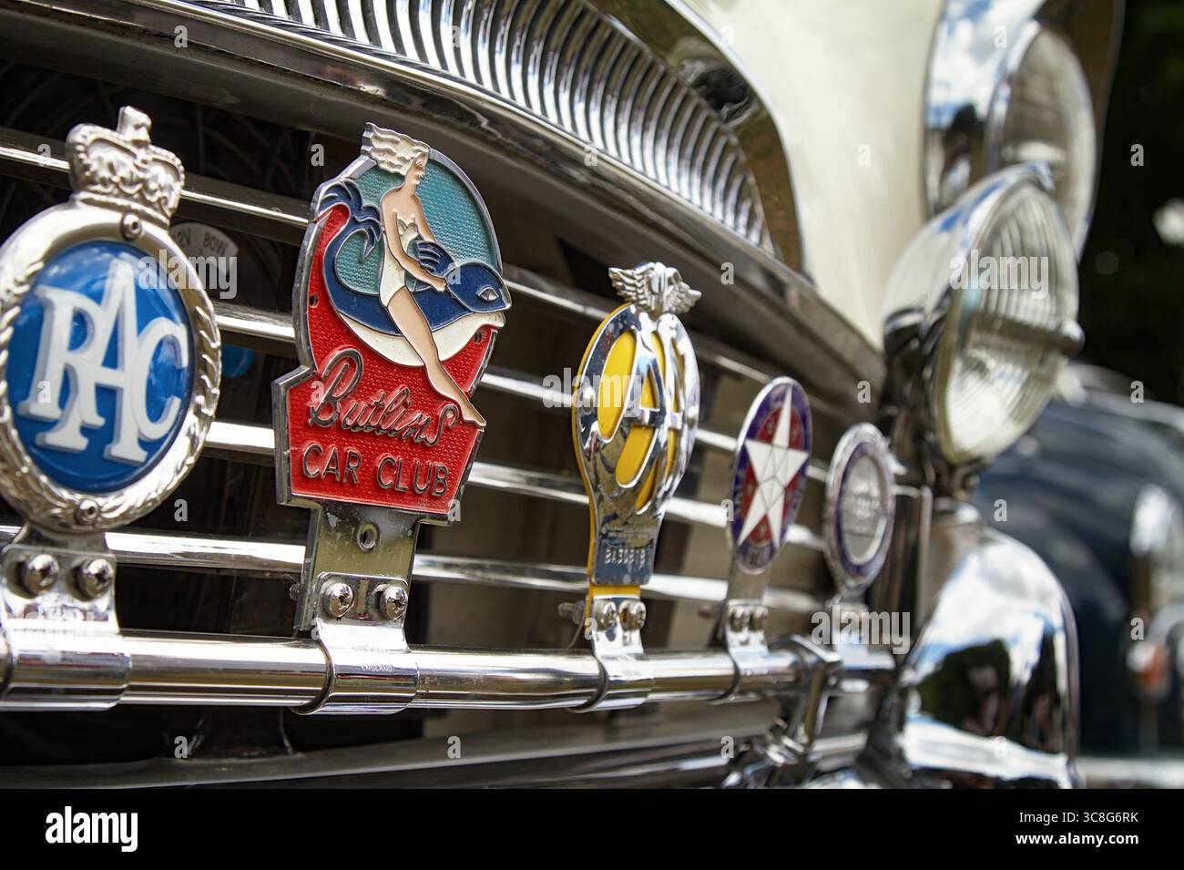 Close Up Of RAC, AA, Butlins Car Club Motor Car Badges Fixed To A Chrome Bumper, Fender Of A Vintage Automobile, UK Stock Photo