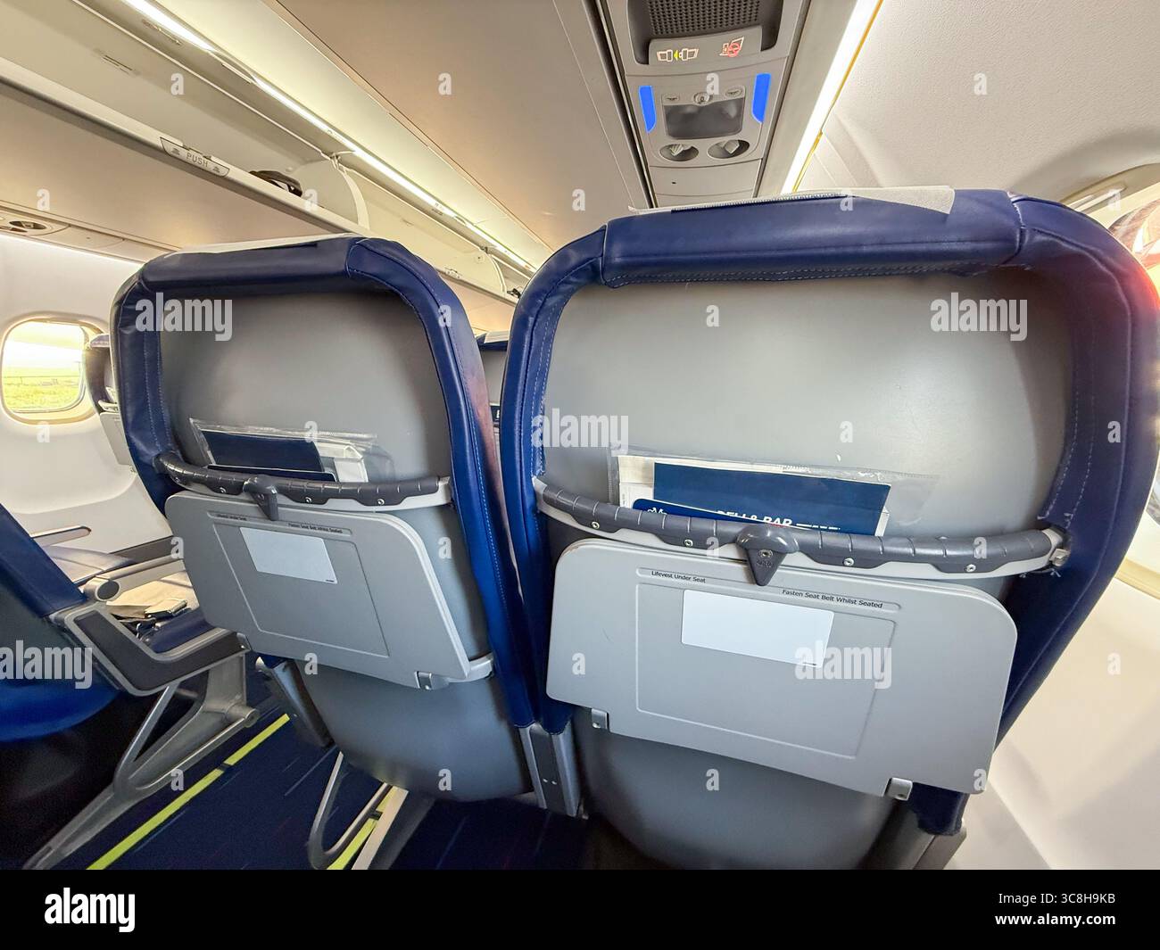 Airplane interior showing back of seats and cabin lighting. Travel ...