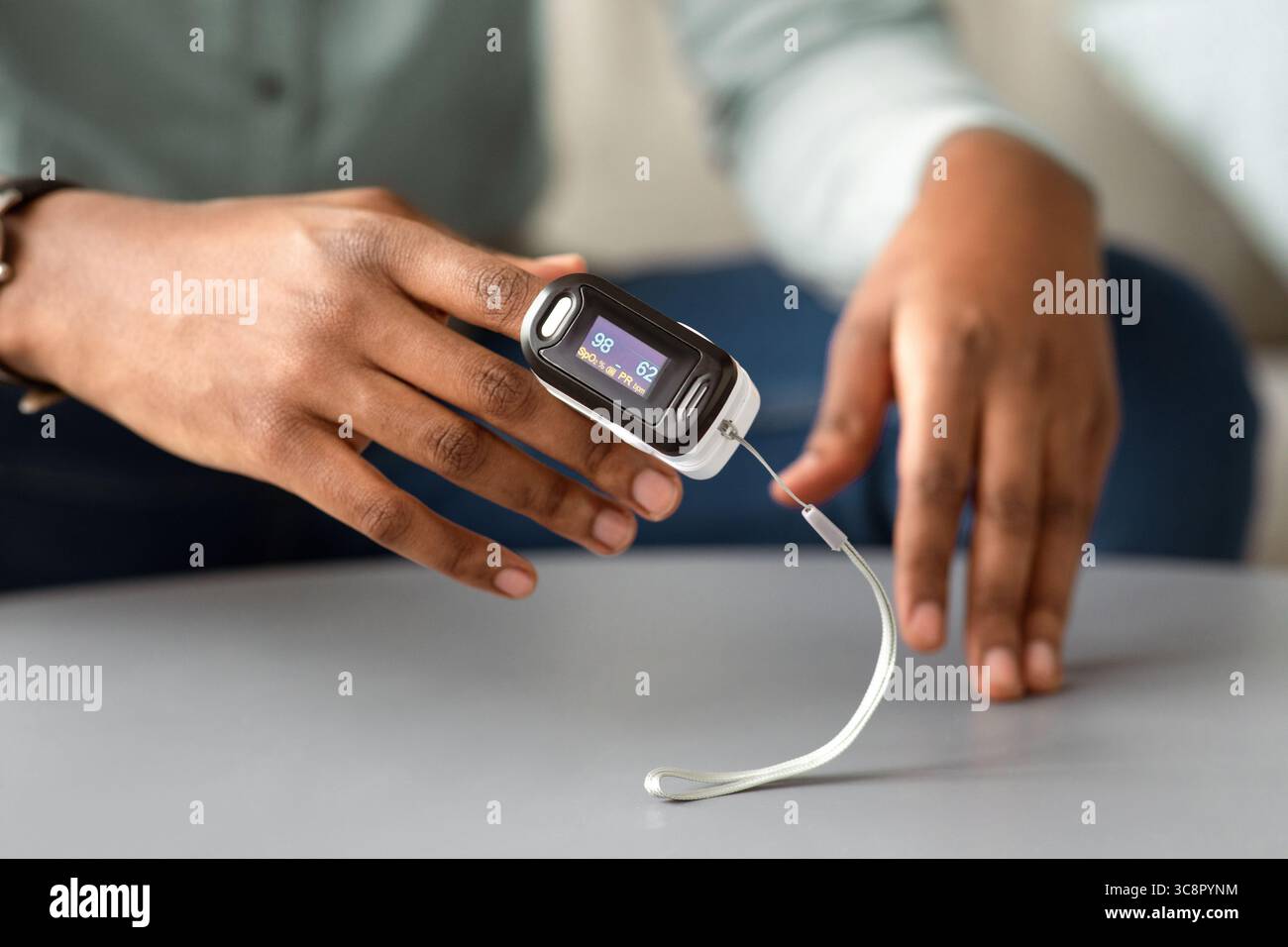 Unrecognizable African Man Using Pulse Oximeter Checking Oxygen Saturation Indoor Stock Photo
