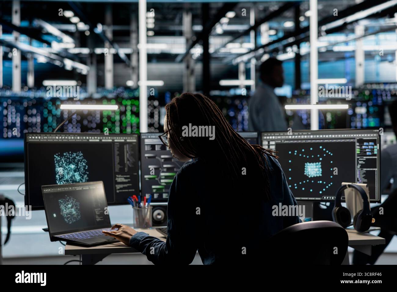Data center system administrator uses AI visualization tool to optimize resource allocation. Server farm staff member uses artificial intelligence analysis software on computer to do maintenance Stock Photo