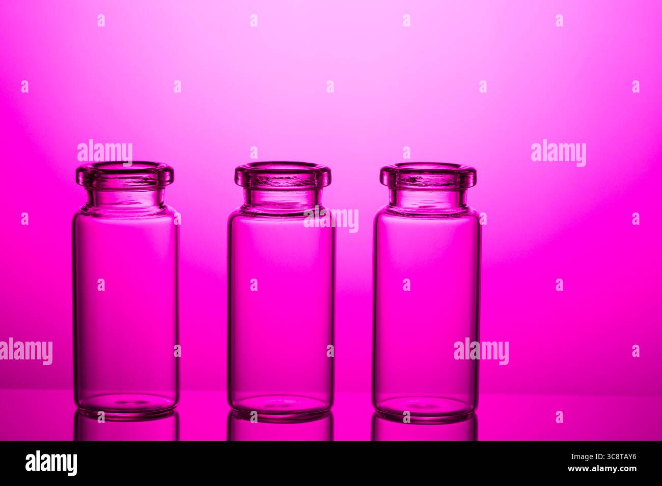Empty little bottles on nice pink background. Stock Photo