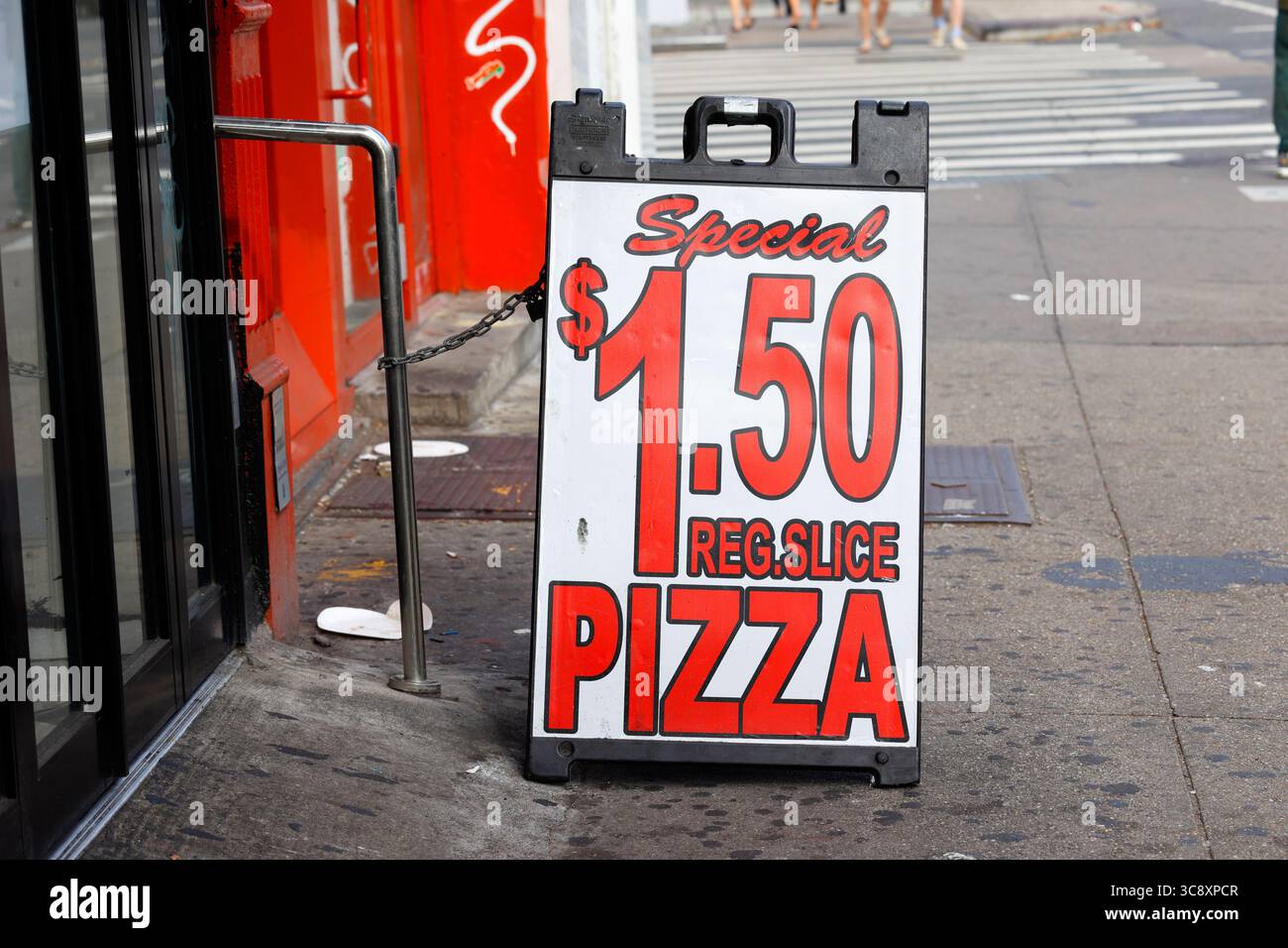 Signage at a New York City pizzeria advertising a regular slice of pizza for $1.50 Stock Photo
