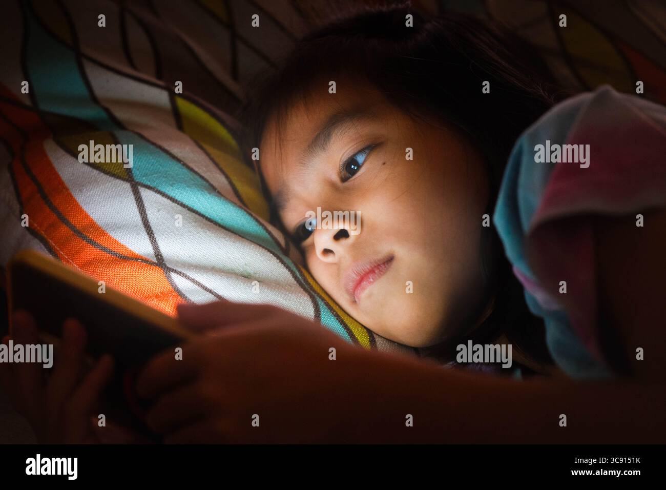 Fresh Look at Asian Girl Using Smartphone At Night With Glowing Screen Concept
