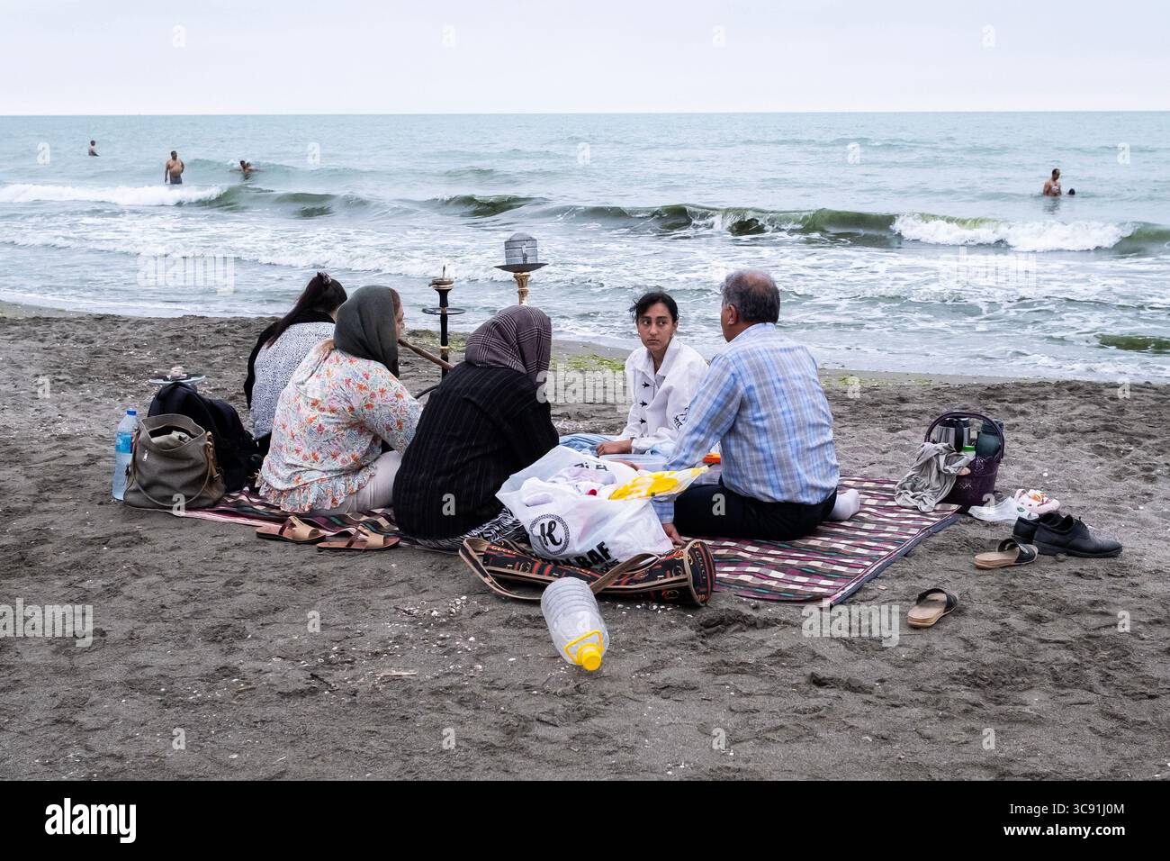 July 31, 2025, Chalus, Iran: A family seen sitting at the beach while ...