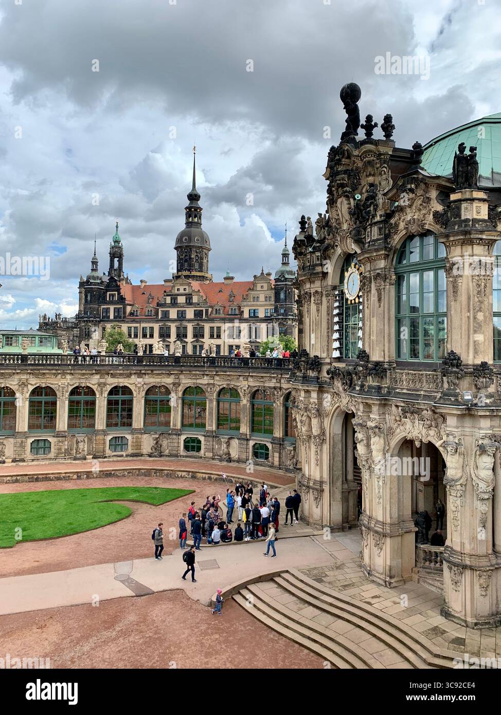 Historic ornate building and city rooftops seen from a public plaza beneath cloudy skies with visitors gathered in the foreground. - Smartphone Captured Stock Image