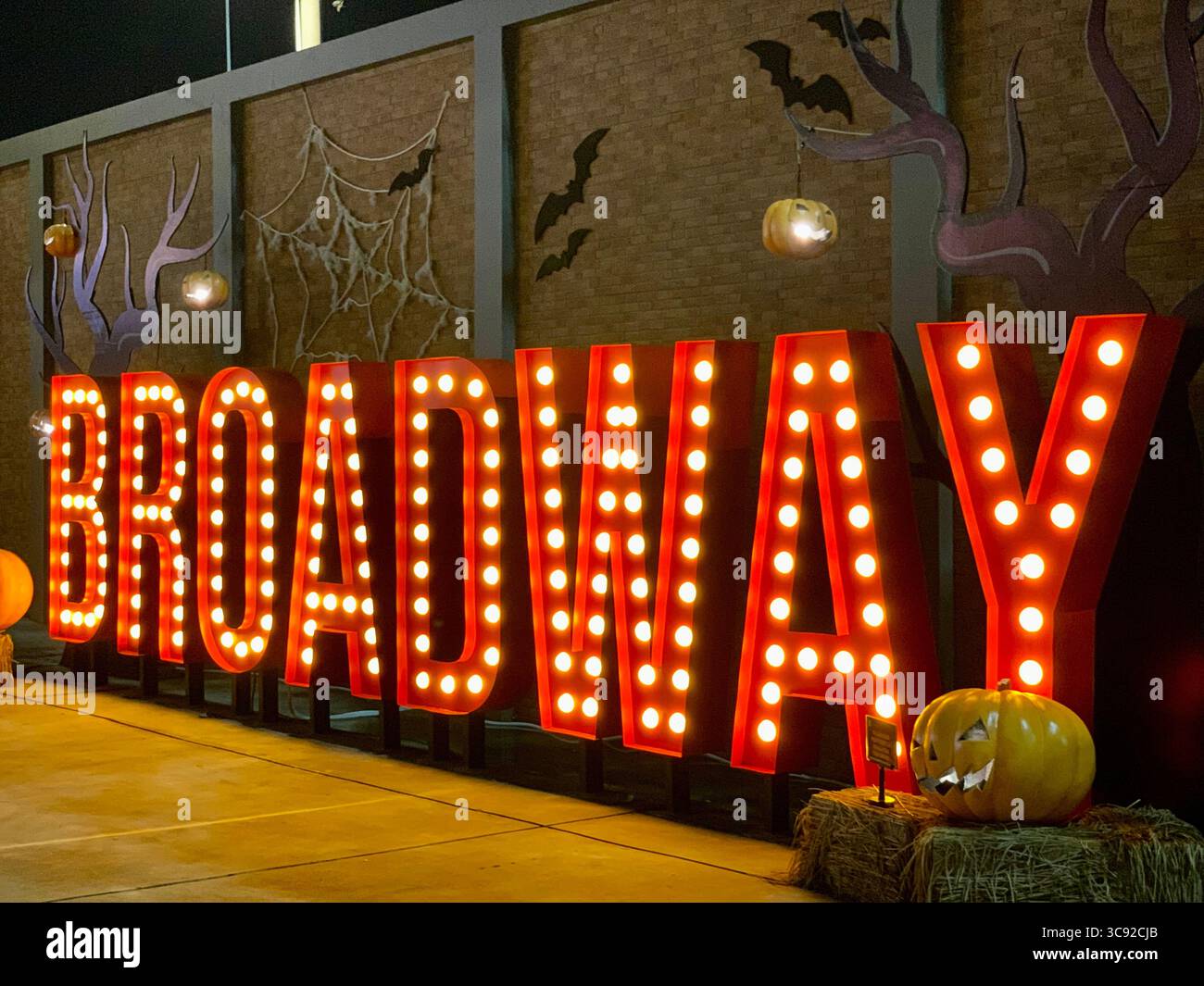 A big broadway entrance text shining at night accompanied by halloween decorations. - Smartphone Captured Stock Image