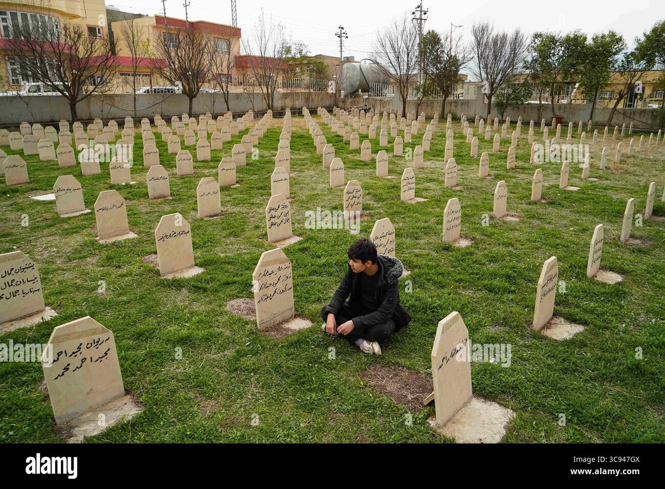 March 16, 2021, Halabja, Sulayman, Iraq: A man sits in the graveyard of the victims of the Halabja chemical attack..The 33rd anniversary of the chemical attack carried out by the Iraqi government on March 16, 1988 on the city of Halabja in the Kurdistan Region, which killed nearly 5000 people and injured 10000 most of them civilians. Thousands of the city's residents died in the year following the attack due to health complications and due to diseases and birth defects. (Credit Image: © Ismael Adnan/SOPA Images via ZUMA Wire) Stock Photo