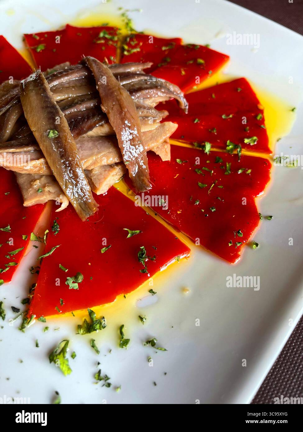 Salad made of Piquillo peppers, tuna loin, anchovy fillets, parsley and olive oil. Spain. - Smartphone Captured Stock Image
