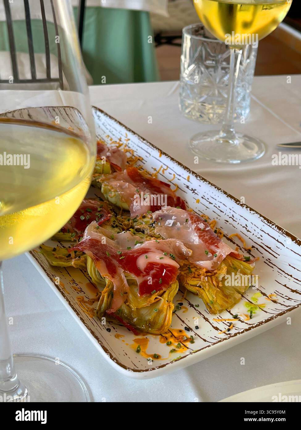 Artichokes with Iberian ham and white whine. Spain. - Smartphone Captured Stock Image