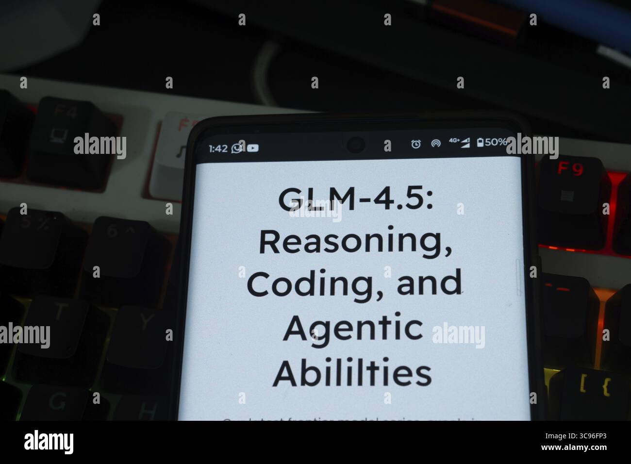 Screen showing GLM-4.5 model's features with a dark, illuminated keyboard Stock Photo