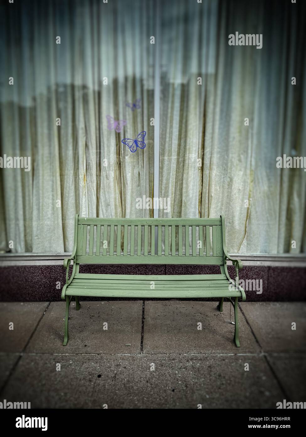 Pale green bench on sidewalk in front of shop window - Smartphone Captured Stock Image