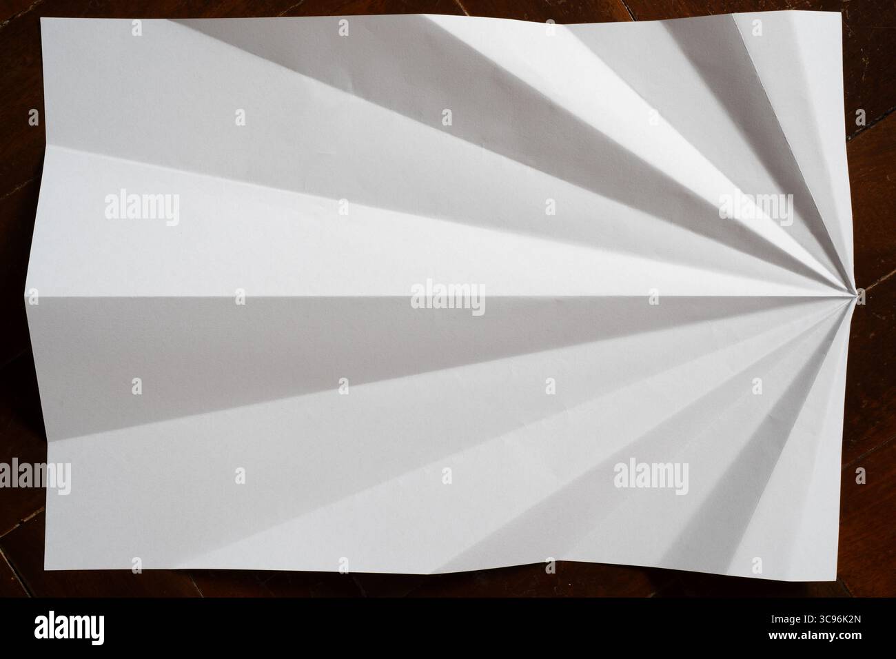 Unfolded Paper Plane Creating Bold Black and White Radiating Design Stock Photo