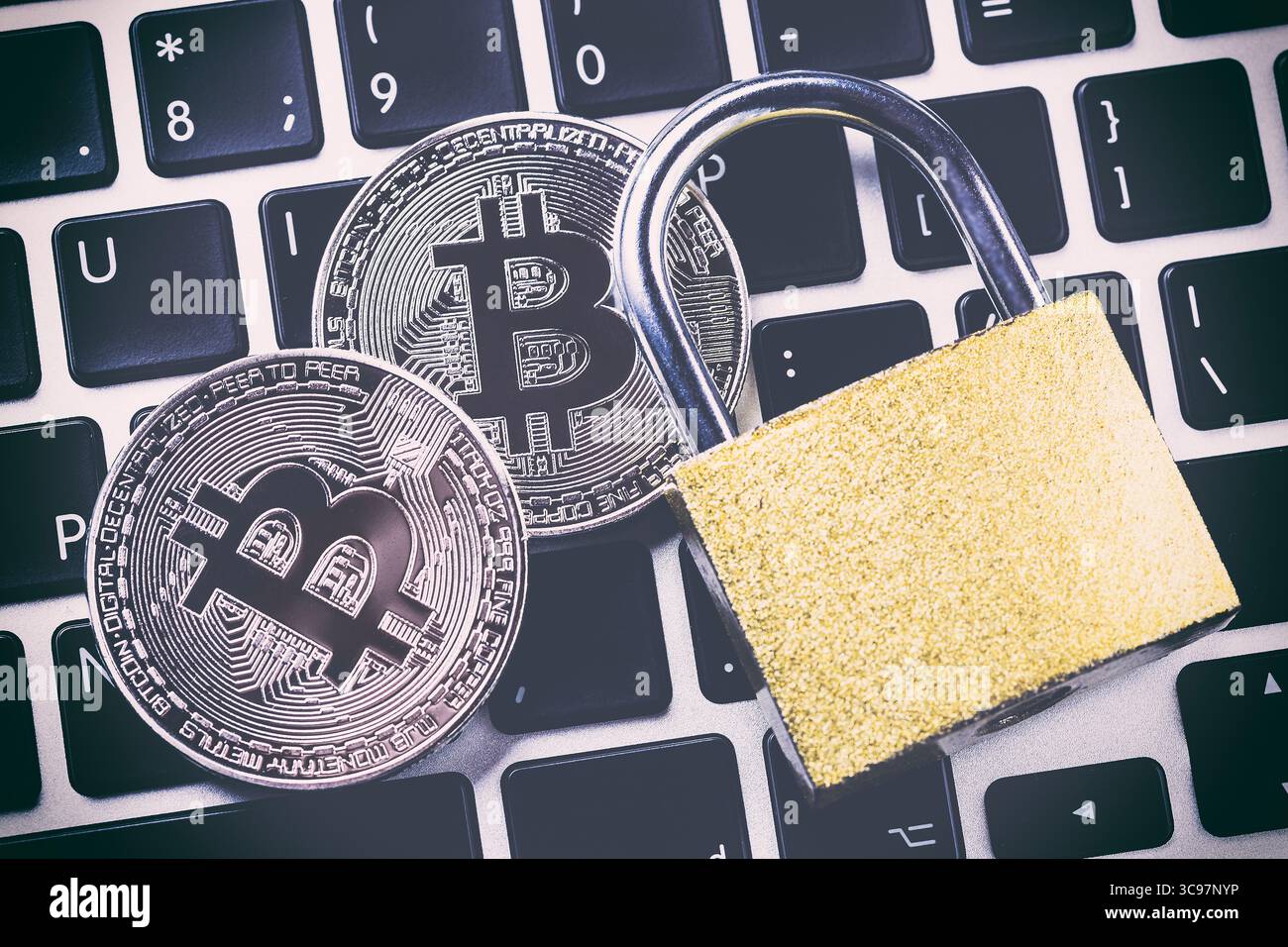 Bitcoin cryptocurrency with padlock on keyboard. Close up image. Stock Photo