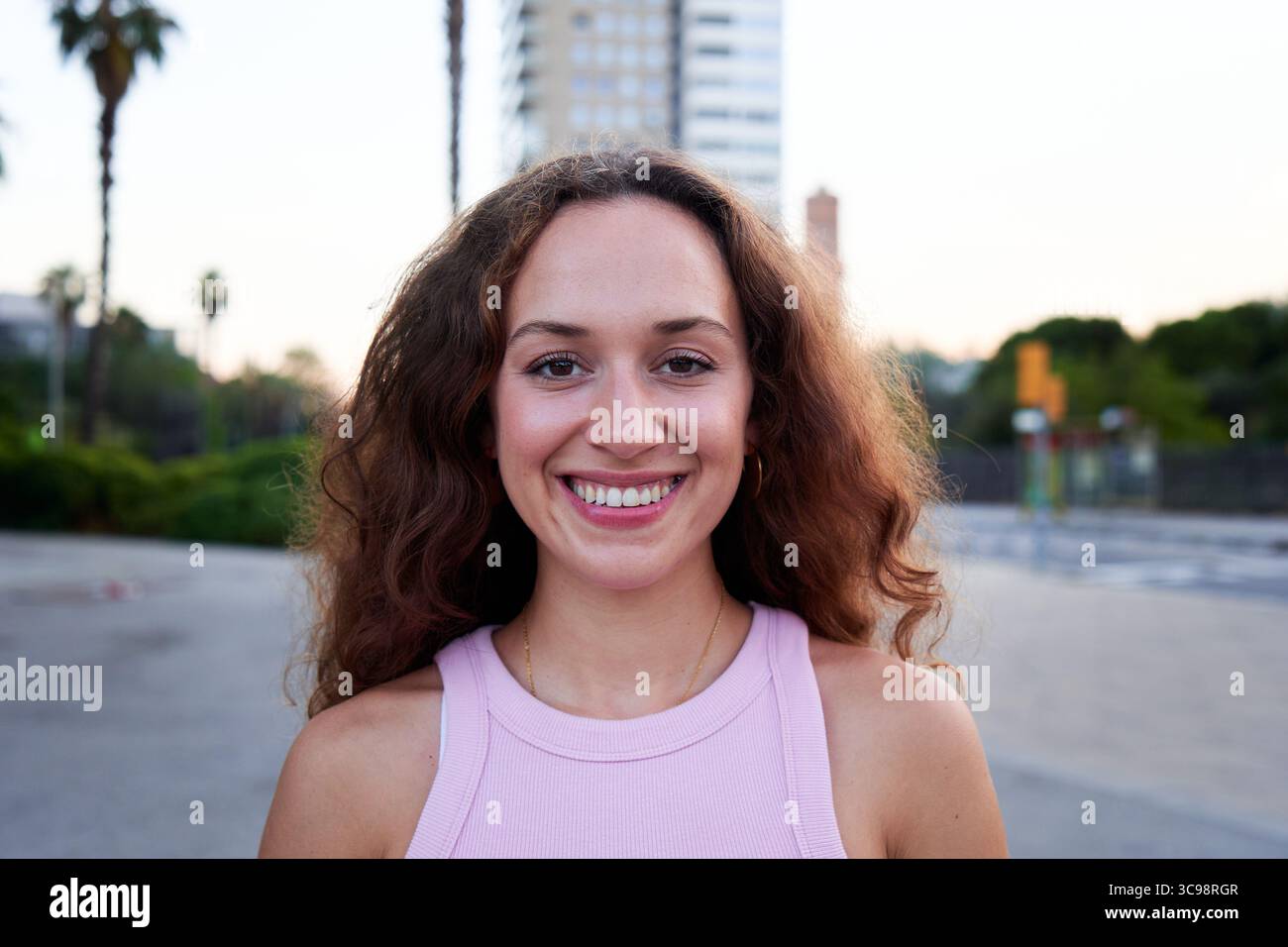 Young woman smiling outdoors in urban city setting. Stock Photo