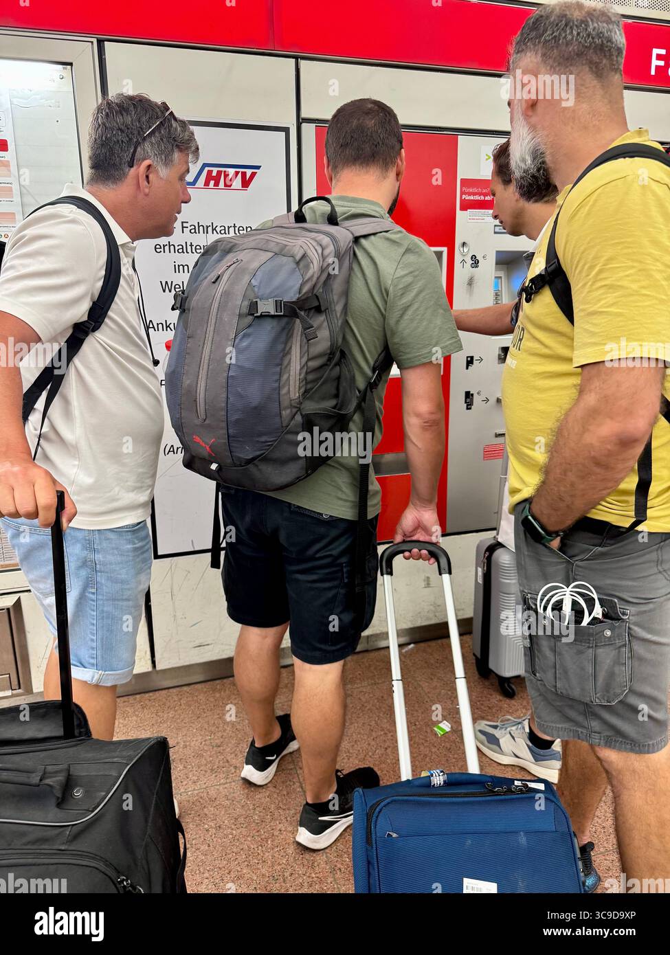Tourists purchasing train tickets at a vending machine in Hamburg Airport, Germany. - Smartphone Captured Stock Image