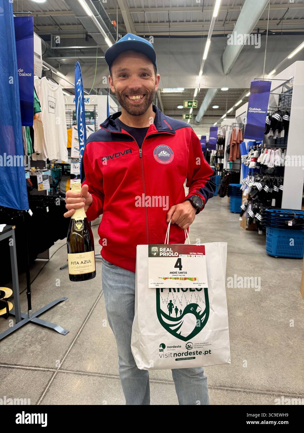 Participants receiving race bibs and swag bags during registration for the Trail Real Priolo running event held in the Azores, Portugal. - Smartphone Captured Stock Image