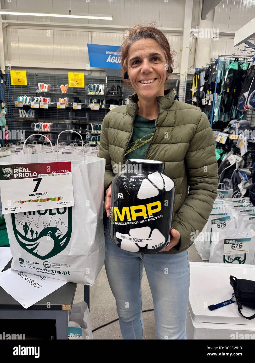 Participants receiving race bibs and swag bags during registration for the Trail Real Priolo running event held in the Azores, Portugal. - Smartphone Captured Stock Image
