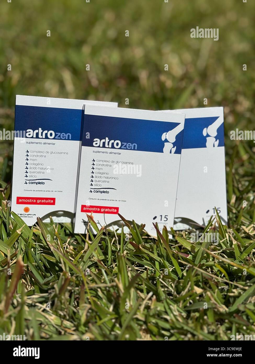 ArtroZen dietary supplement boxes displayed on green grass in natural outdoor light. - Smartphone Captured Stock Image