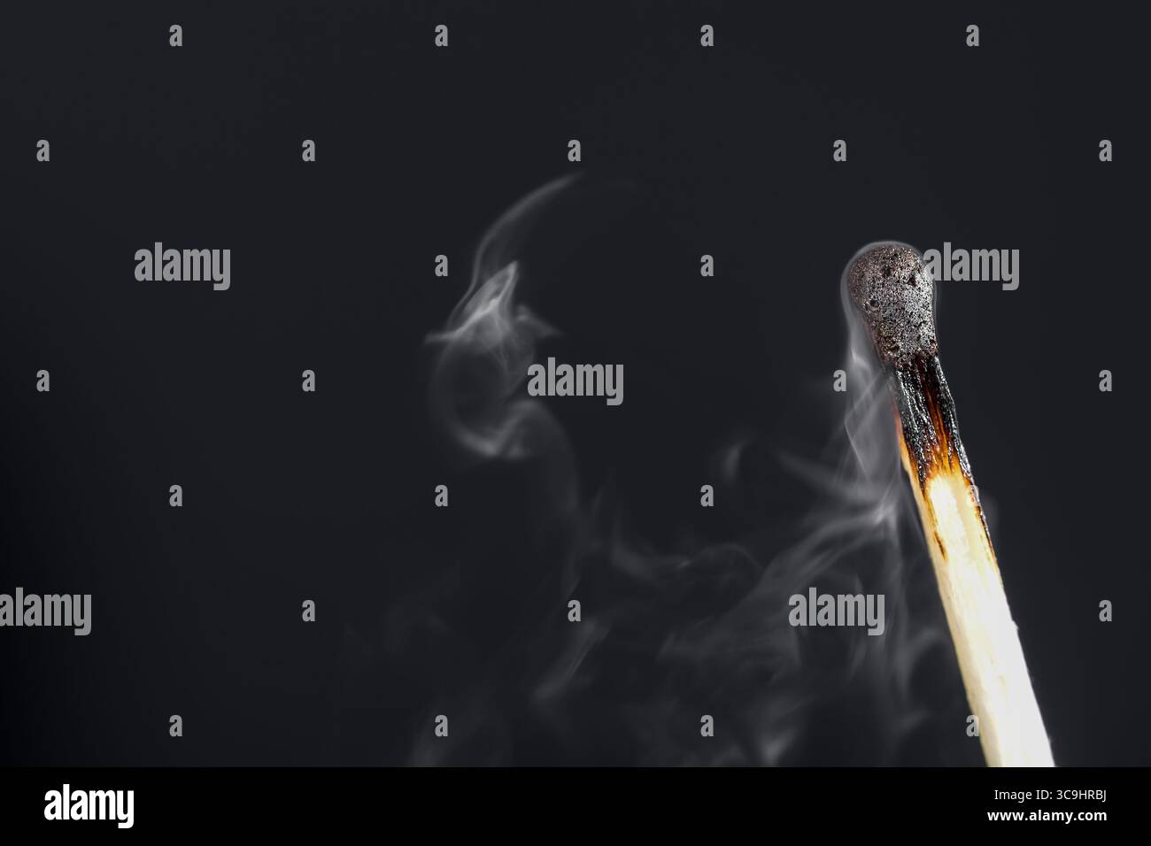 Extinguished match close up with smoke on dark background Stock Photo