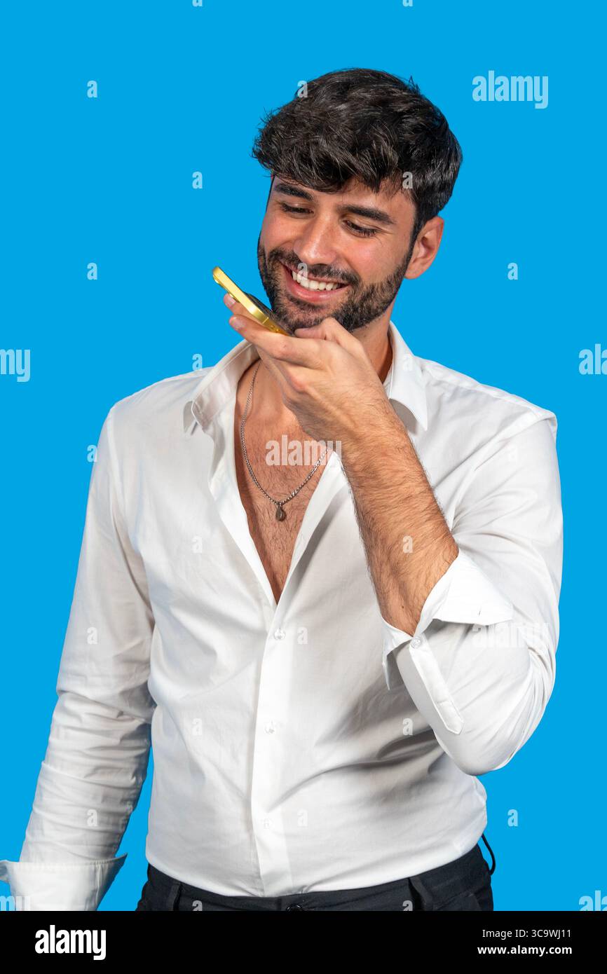 Man interacting with smartphone using voice command against blue background Stock Photo
