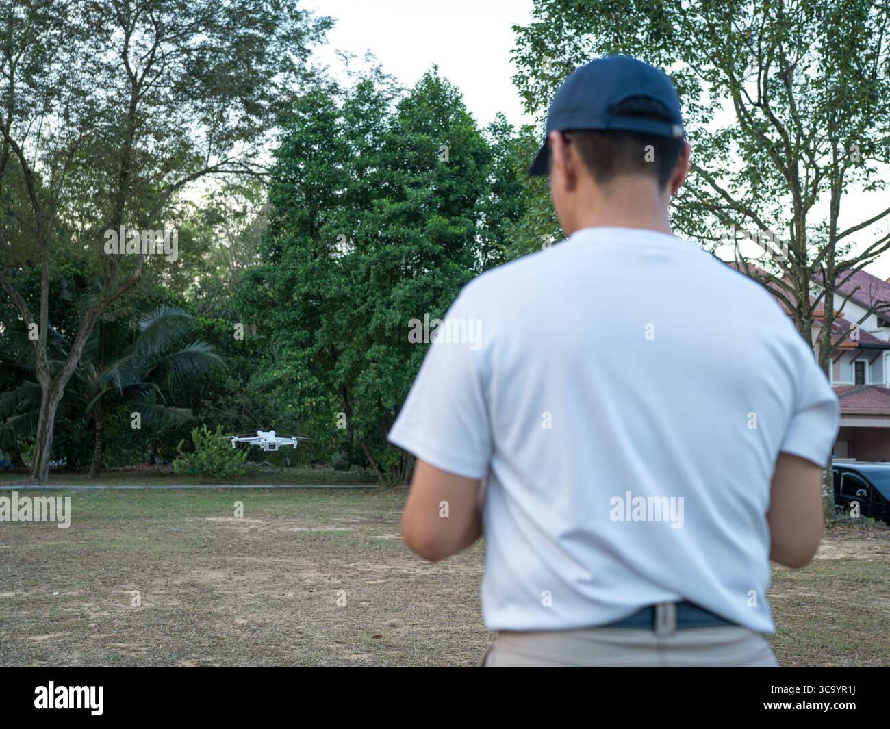 Man back view operating drone outdoor. Stock Photo
