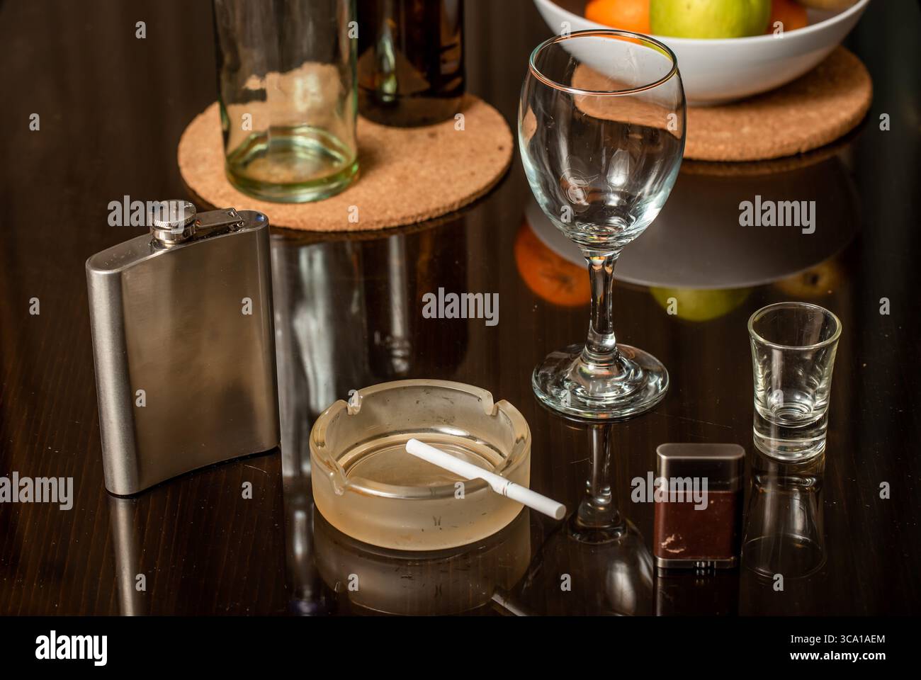 Cigarette in ashtray and cigarette lighter on a dark background Stock Photo