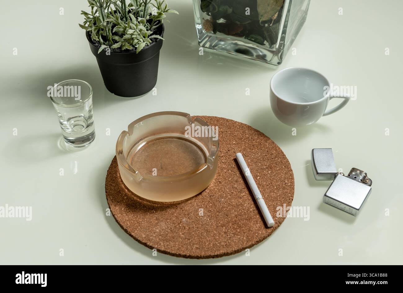 Cigarette in ashtray and cigarette lighter on a white background Stock Photo