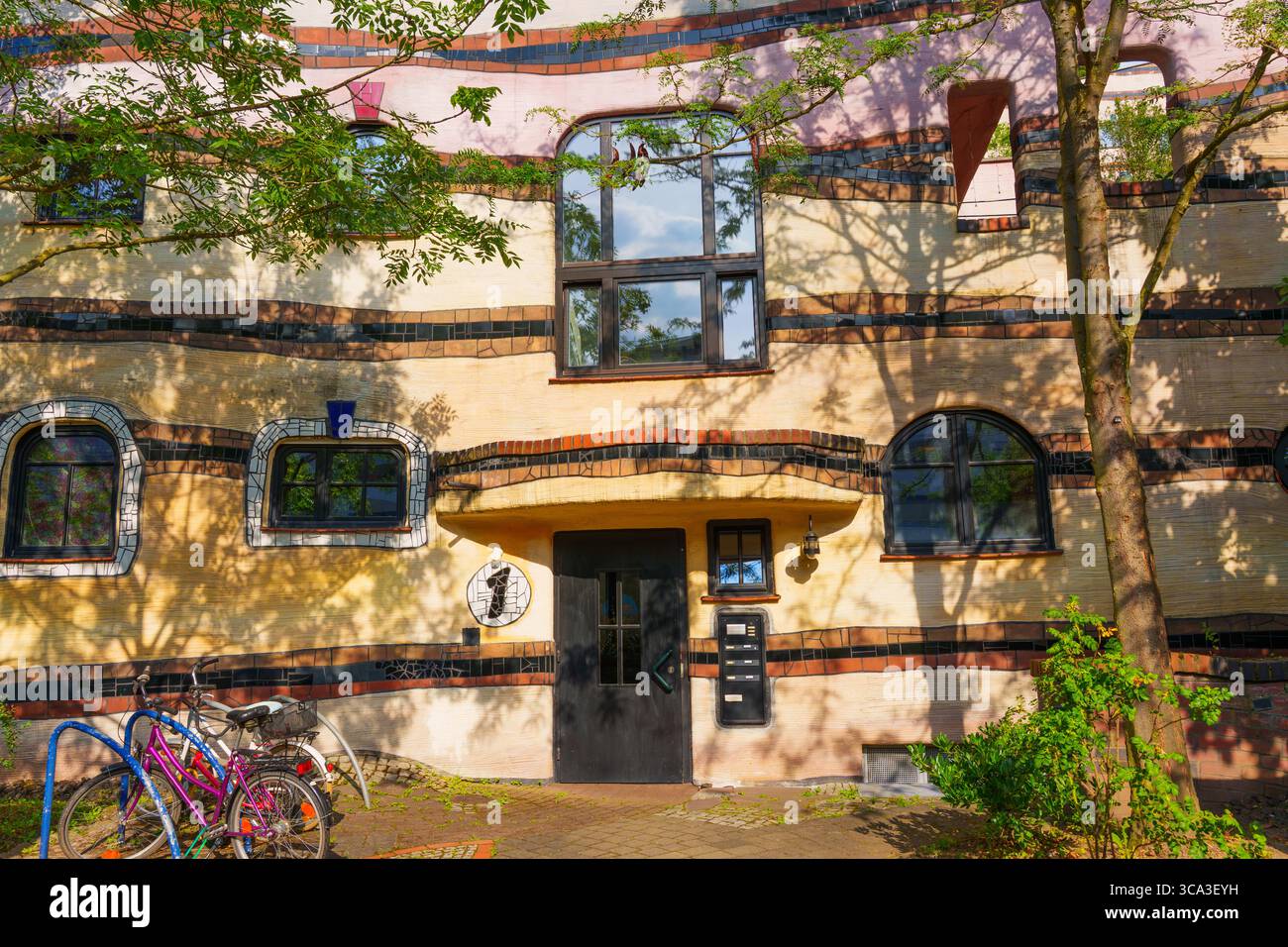 Colorful facade of the Waldspirale residential complex, showcasing its curved lines, organic forms, and vibrant colors, surrounded by greenery and bic Stock Photo