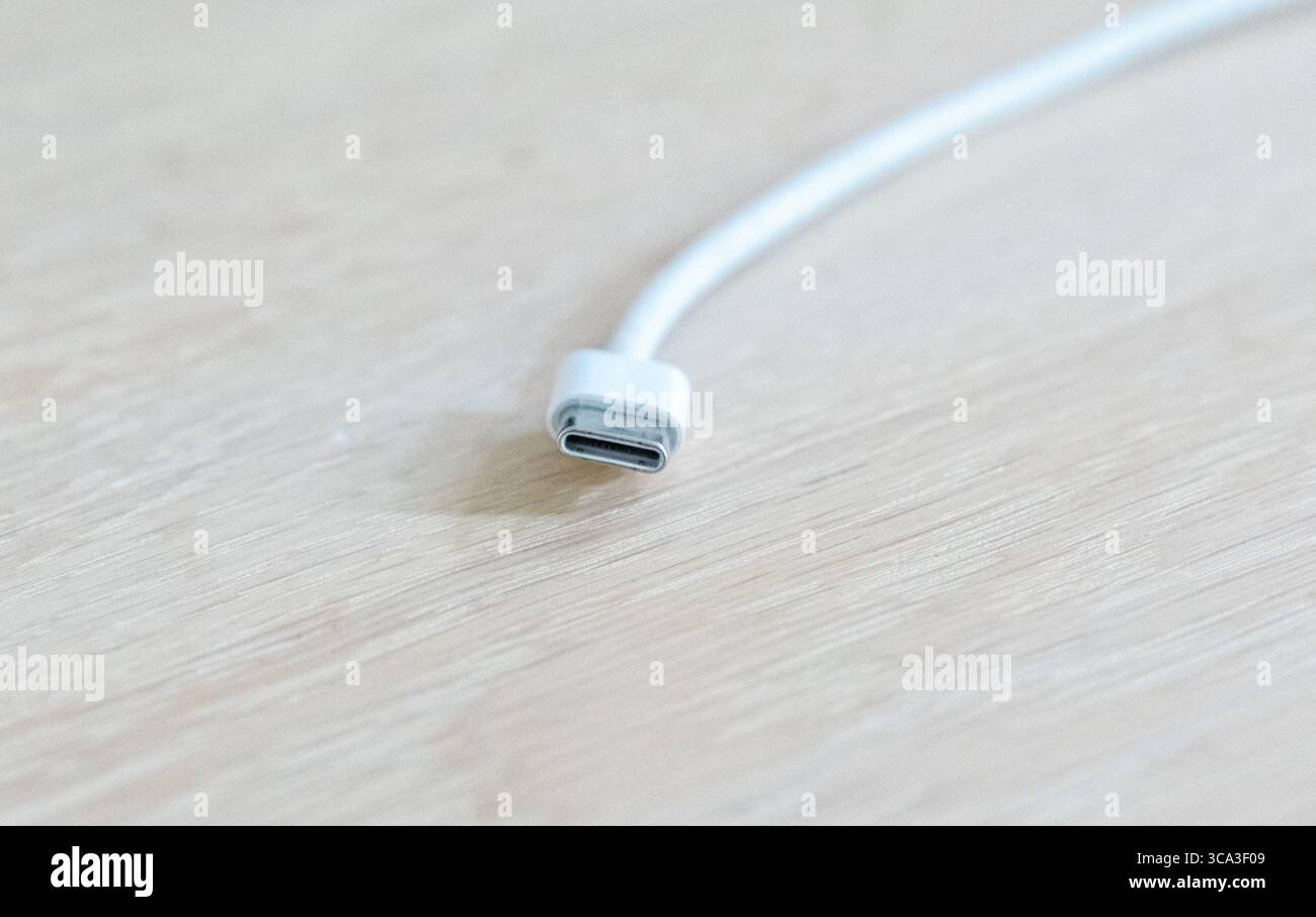 August 2025 White iPhone USB-C cable plug close up on a table Stock Photo